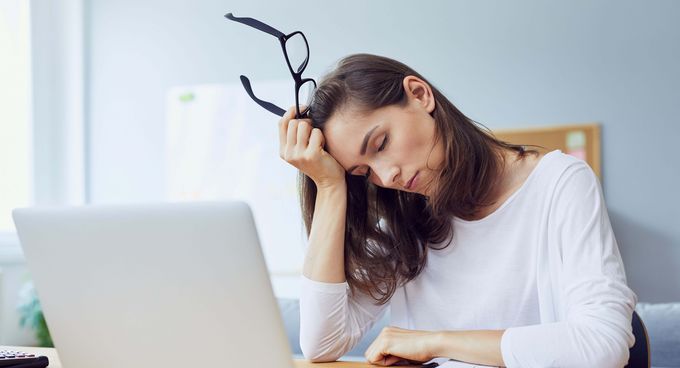 traurige Frau stützt ihren Kopf auf die Hand