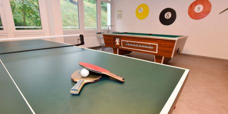 Tischtennisschläger und Bälle liegen auf der Tischtennisplatte