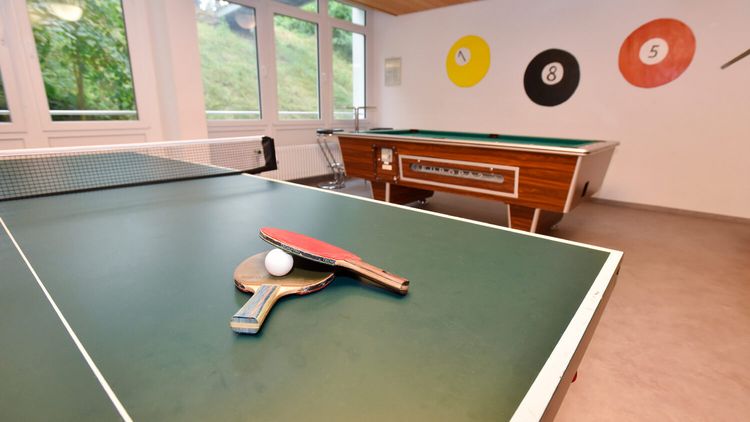 Tischtennisschläger und Bälle liegen auf der Tischtennisplatte