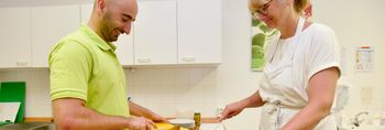 Therapeut und Patientin kochen in der Lehrküche