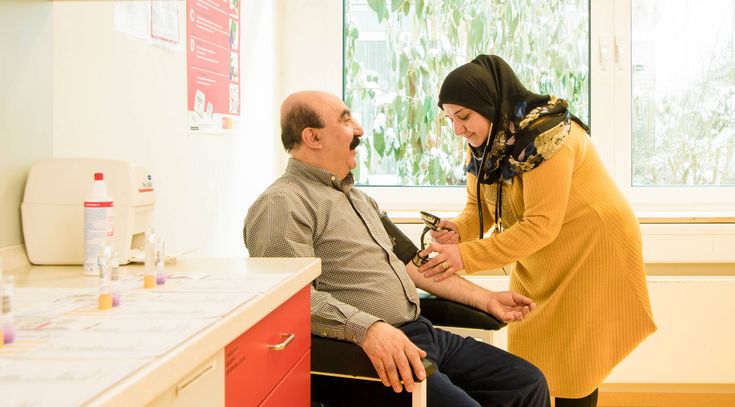 Pflegekraft misst Blutdruck eines Patienten