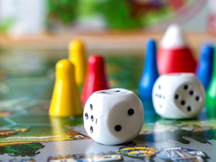 Spielfiguren und Würfel auf einem Spielbrett