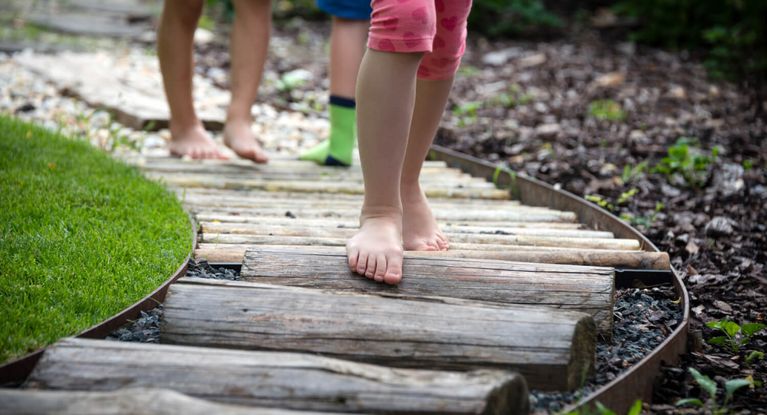 Für alle Sinne Kinder spazieren auf einem Barfußpfad