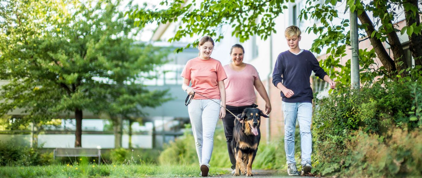 Patienten und Therapeitin mit dem Therapiehund unterwegs