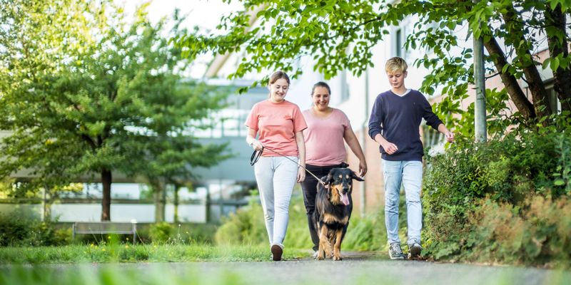 Patienten und Therapeitin mit dem Therapiehund unterwegs