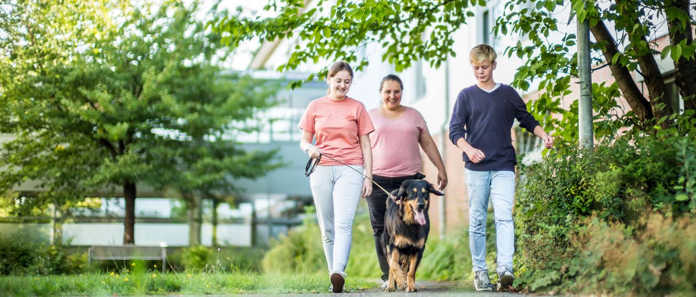 Patienten und Therapeitin mit dem Therapiehund unterwegs