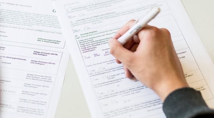 Hand mit Stift füllt Formulare aus